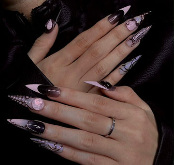 Long stiletto nails with pink and black 3D nail art, rhinestones, and glossy finish